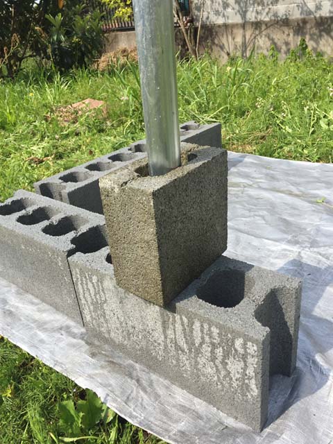 重量ブロックに単管パイプを入れてモルタルで固定する